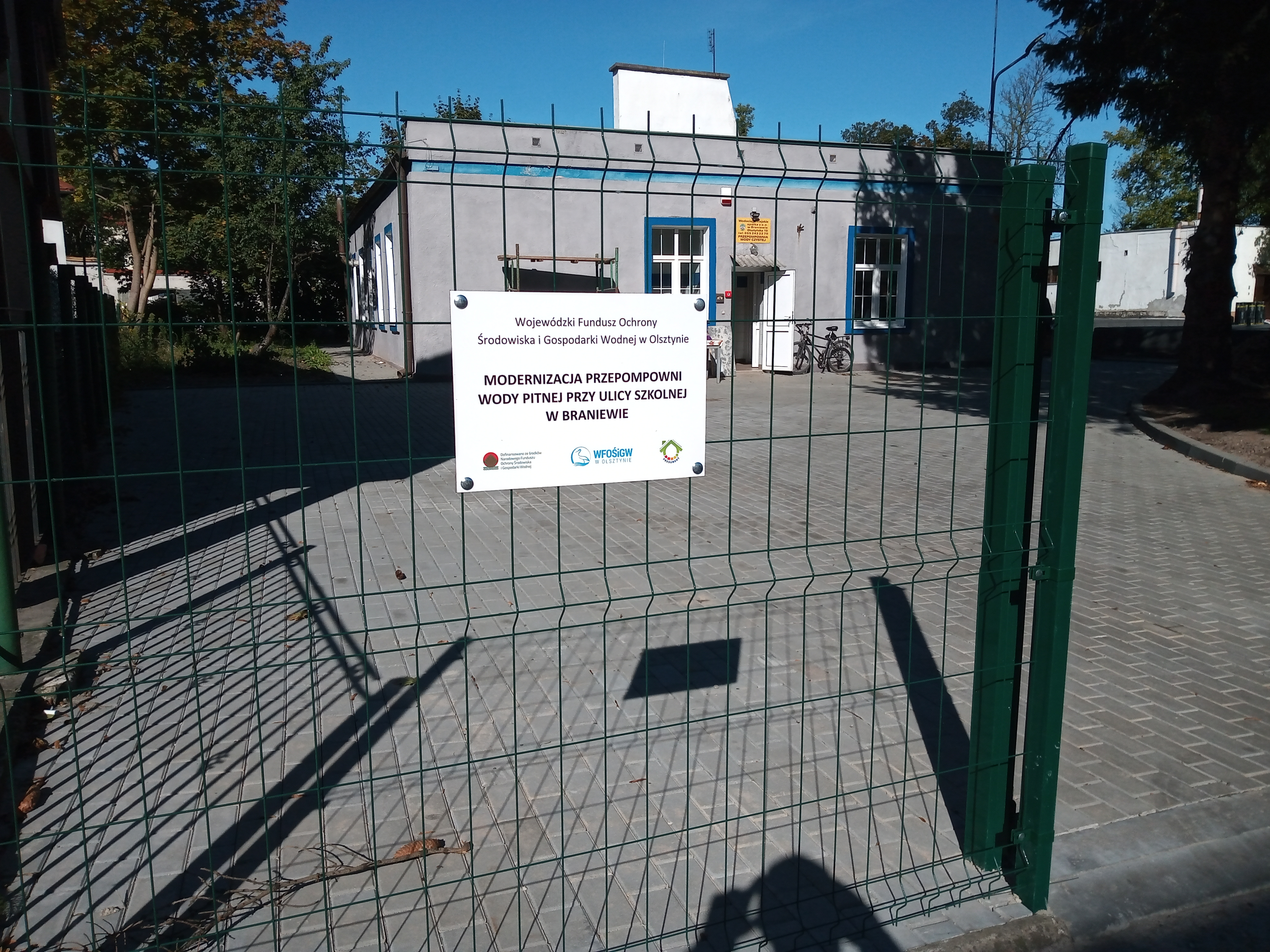 Brama przepompowni z tabliczką informującą o inwestycji