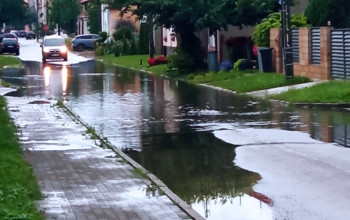 Asfaltowa droga w obszarze mieszkalnym jest zalana przez ulewne deszcze z powodu problemów z odwodnieniem.
